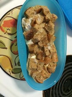 a blue bowl filled with food sitting on top of a stove