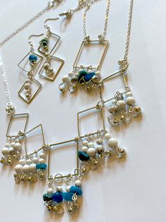 Create a sleek delicate look with this geometric pattern necklace set. The glint of metal squares enhance the dark soft blue color of natural blue agatite. White howlite beads draw attention to the allure of blue drops in the metal squares. Dangle strings of blue agatite and white howlite with these jewels to increase the grandeur of your attire. For a truly eye-catching appearance, display these designs in style. Adjust length of the bracelet with included jump rings. Gemstone - Natural blue agatite, white howlite Beads - Gemstone beads, glass beads Color - White with grey flecks, blue and green shades of dark teal blue, metallic gray Necklace and bracelet chain - Trace chain Closure - Lobster claw Earring style - Dangling hoops Other materials - Metal square hoops, jump rings, jewelry pi Claw Earrings, Rings Gemstone, Gray Necklace, Green Shades, Bracelet Chain, White Howlite, Jewelry Pins, Rings Jewelry, Blue Necklace