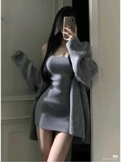 a woman is taking a selfie with her cell phone wearing a gray sweater dress