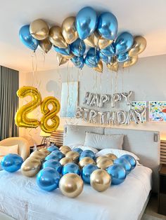 a bed with blue and gold balloons in the shape of numbers on top of it