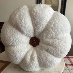 a white round pillow sitting on top of a table