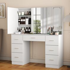 a white vanity with drawers and mirrors in a room