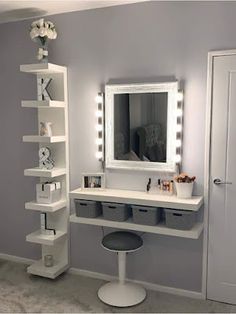 a white vanity with lights on it and a mirror in the corner next to it