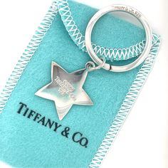 a silver keychain with a star on it and the words tiffany & co