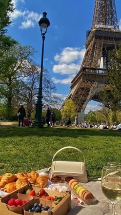 a table with food and wine in front of the eiffel tower