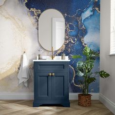 a bathroom vanity with a blue cabinet and mirror on the wall next to a potted plant