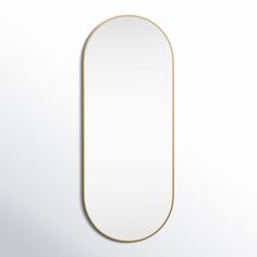 an oval mirror hanging on the wall with a gold frame in front of white background