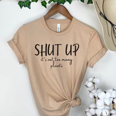 "Looking for the perfect botanical gardening gift? Check out our Plant Mom and Plant Dad tees, or our Plant Lover shirt that celebrates all things green! Our Plants tee is a must-have for any gardening enthusiast. Shop our collection of clothing and find the ideal gift for the plant lover in your life.  \"Shut up, its not too many plants\", sarcastic plant lover shirt. The Bella Canvas 3001 Unisex T-shirt is super soft cotton and quality colour. **The design is made to look \"vintage\" faded and will look slightly opaque to give that well-worn retro feel. ★ 100% Soft cotton (fibre content may vary for different colors) ★ Runs true to size * Unisex t shirt fits like a well-loved favorite, featuring a crew neck, short sleeves and designed with superior airlume combed and ring-spun cotton tha Cotton T-shirt With Plant Detail, Short Sleeve, Cotton Graphic Print T-shirt For Gardening, Cotton T-shirt With Graphic Print For Gardening, Cotton T-shirt With Letter Print For Gardening, Crew Neck Cotton T-shirt With Plant Details, Cotton Crew Neck T-shirt With Plant Details, Crew Neck Cotton Shirt For Gardening, Cotton Crew Neck T-shirt With Plants, Casual Cotton Shirt For Gardening