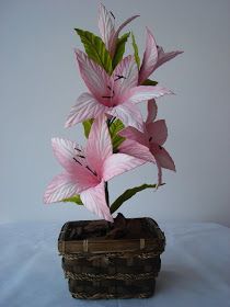 a pink flower is in a basket on a table