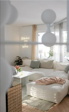 a living room filled with white furniture and lots of windows