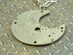 "This a beautiful and unique upcycled pendant necklace in the shape of the waning moon. The pendant is a repurposed antique pocket watch bridge made of silver-tone, non magnetic metal (unknown if silver - untested). A beautiful etched pattern runs across the face of the bridge. Antique or vintage from a time when what was hidden inside a watch was meant to be as elegant as what was visible on the outside. Along with the spiral pattern, the pendant shows a serial number and the finely etched word Vintage Sterling Silver Moon Phase Jewelry, Vintage Moon Phase Round Pendant Jewelry, Vintage Silver Jewelry With Moon Phase, Vintage Silver Necklace With Moon Charm, Vintage Sterling Silver Moon Phase Necklace, Vintage Metal Moon Necklace, Vintage Moon-shaped Metal Necklace, Vintage Moon Shaped Metal Necklace, Vintage Moon Charm Round Pendant Necklace