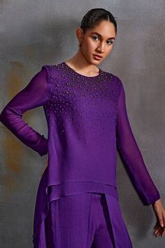 Purple full sleeves high low tunic with spluttered sequin, crystals highlights. Paired with petal hem pant.
Components: 2
Pattern: Embroidery
Type Of Work: Sequin, Crystals
Neckline: Round
Sleeve Type: Full
Fabric: Textured Georgette
Color: Purple
Occasion: Party - Aza Fashions Embellished Georgette Tops For Party, Long Sleeve Georgette Party Tops, Long Sleeve Georgette Tops For Party, Evening Georgette Tops With Sequins, Evening Sequined Georgette Tops, Glamorous Hand Embellished Long Sleeve Sets, Glamorous Long Sleeve Hand Embellished Sets, Embellished Long Sleeve Sets For Reception, Glamorous Embellished Sets