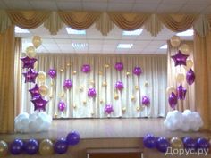 balloons and streamers decorate the stage for a party