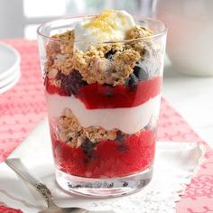 three glasses filled with yogurt and granola on top of a wooden table