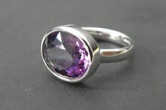 Minimalist amethyst ring in silver 925. The ring rail in omega shape was specially developed by me to allow transparent and translucent gemstones as much light incidence. The stone gets its full luminosity and intense colour. A ring for lovers of minimalist fine jewellery The ring has a stock size of US 7,25 - UK N 1/4 The ring size will be adjusted to the customer's size at no extra cost. When buying please note the desired size in the comment field. Amethyst 14x12mm - 6,66ct Silver 925, Sterli Modern Amethyst Ring With Bezel Setting, Modern Amethyst Ring As Gift, Modern White Gold Amethyst Ring, Modern Sterling Silver Amethyst Ring For Formal Occasions, Modern Sterling Silver Amethyst Ring, Modern Sterling Silver Amethyst Ring With Polished Finish, Modern Amethyst Ring With Polished Finish, Modern White Gold Amethyst Ring As Gift, Modern Polished Amethyst Ring