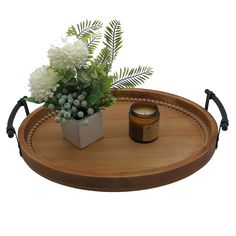 a wooden tray with a candle and flowers on it