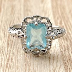 Radiant Cut Aquamarine Art Deco Filigree Ring. 925 Sterling Silver. Classic Light Blue Ring In Sterling Silver, Blue Topaz Jewelry With Halo Setting For Gift, Blue Topaz Jewelry With Halo Setting As A Gift, Light Blue Jewelry With Prong Setting For A Gift, Silver Aquamarine Fine Jewelry, Silver Blue Topaz Hallmarked Rings, Silver Blue Topaz Rings Hallmarked, Silver Aquamarine Jewelry With Halo Setting, Silver Hallmarked Rings With Blue Topaz