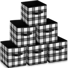 four black and white plaid boxes stacked on top of each other, with one in the middle