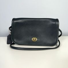 "Classic vintage Coach Dinky cross body in Navy with brass hardware. A nice smaller sized cross body bag. The perfect classic staple! Made between the mid-1980s and 1994 this bag is in nice vintage condition (see details below). It is Navy but appears almost black in some light because it is very dark blue. Coach's glove tanned leather was meant to last a lifetime and this bag is ready to live its second life!  Exterior features: - Brass turn lock - Long tubular strap (22\" drop) - Original side sided hang tag Interior features: - Interior slim zip pocket - Unlined full grain leather Condition In good vintage condition. Normal signs of age including light scuffs and a couple tiny light spots (see photos). Overall the piping and corners are in good condition. No tears or holes. Interior is Vintage Rectangular Flap Bag With Gold-tone Hardware, Classic Canvas Shoulder Bag, Classic Flap Bag For Daily Use, Classic Flap Shoulder Bag, Classic Flap Bag With Removable Pouch, Classic Travel Flap Bag, Vintage Evening Flap Bag, Classic Flap Bag With Gold-tone Hardware, Classic Crossbody Satchel With Removable Pouch