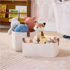 several stuffed animals are in a basket on the floor next to a toy pig and other toys