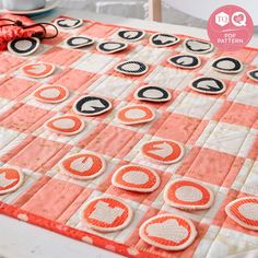 an orange and white checkered table cloth with black circles on it, next to some scissors