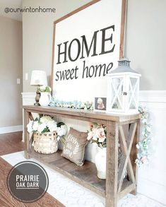 a wooden table topped with baskets filled with flowers next to a sign that says home sweet home