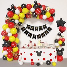 a mickey mouse birthday party with balloons and decorations