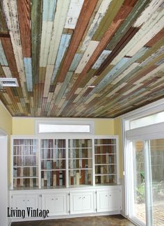 an empty room with many bookshelves and cabinets on the ceiling that are painted multi - colored wood planks