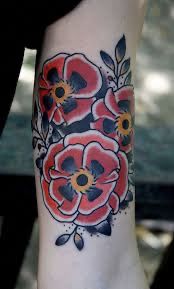 a woman's arm with red and black flowers on it