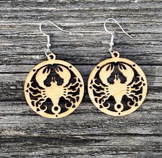 Designed in house, our Zodiac line of earrings is exclusive to Country View Studios.  The detail, intricate and precise, is stunning.   The laser cut Scorpio Scorpion Zodiac earring is crafted from baltic birch and measures approximately 2 1/2" (earring + ear wire)/ 1 1/2" (wood only) long.  Hardware is crafted from 925 sterling silver. As wood is a natural substance, each piece is unique. Grain, texture and color may vary slightly from pictured image.  Each pair of earrings is carefully tucked into a simple kraft paper cardboard box tied with natural jute twine.  Perfect for gift giving or as a gift for yourself.   Many of our designs contain small component parts which may present a choking hazard if ingested.  Be sure to keep these out of the reach of young children, animals or others t Silver Laser Cut Earrings As Gift, Scorpions Zodiac, Wood Dangle Earrings, Scorpion, Natural Jute, Favorite Jewelry, Jewelry Earrings Dangle, Dangle Drop Earrings, Dangle Earrings