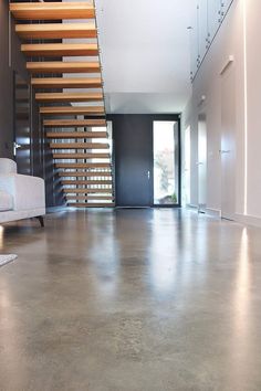 an empty living room with stairs leading up to the second floor