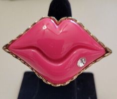 a pink lipstick shaped object on top of a black stand