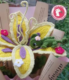 a crocheted butterfly brooch with flowers on it's wings and leaves