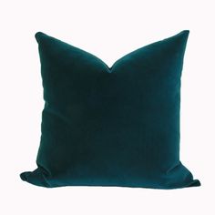 a dark green pillow on a white background