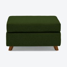 a green footstool sitting on top of a white floor