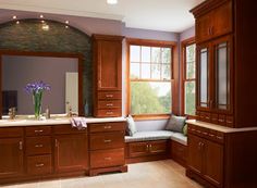 a large bathroom with wooden cabinets and window sill, along with a bench in the middle