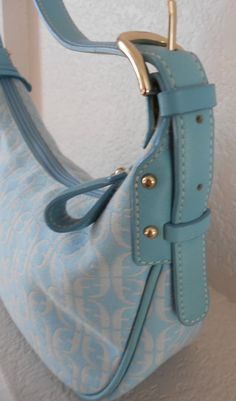 "Beautiful and cute clutch/shoulder handbag Light sky blue, leather trim, adjustable strap Logo on canvas and the key Zipper closure Three pockets: two open pockets: one small and the other larger and one zipper pocket Interior stain - see photo. Otherwise, it's in great condition. No stain on canvas Dimensions Width 10 2/4\" Height 5 1/2\" Depth 4\" Strap length 25 1/2\" Strap drop 9 1/2\"" Blue Shoulder Bag With Metal Hardware For Everyday Use, Blue Shoulder Bag With Metal Hardware And Double Handle, Blue Shoulder Bag With Metal Hardware For Travel, Blue Shoulder Bag With Metal Hardware, Everyday Blue Shoulder Bag With Metal Hardware, Blue Tote Shoulder Bag With Metal Hardware, Yellow Leather Bag, Burlap Tote Bags, Vegan Tote Bag