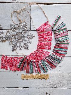 an ornament, snowflake and christmas decorations on a white wooden background