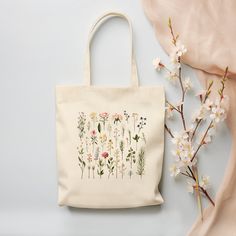 a tote bag sitting next to some flowers