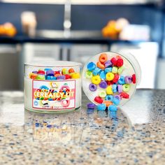 there is a jar of beads next to a bowl of candy on the kitchen counter