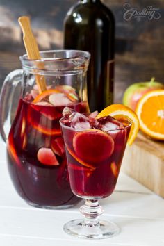 two glasses filled with liquid next to sliced oranges