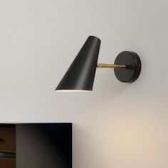 a black lamp is on the wall next to a dresser