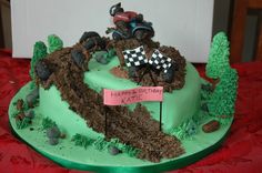 a birthday cake that is decorated with dirt and tractor tracks, trees, and a sign saying happy birthday kate