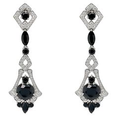 These exquisite earrings are crafted with meticulous attention to detail, inspired by the glamour and precision characteristic of the Art Deco era. At the heart of these earrings lie the captivating black spinels, each boasting a generous 4.70 carats. Surrounding the central spinels are an array of additional spinel gemstones, totaling an impressive 7.28 carats. Enhancing the elegance of these earrings are the shimmering F/G colored natural diamonds, totaling .79 carats. Set delicately in 18k white gold, these diamonds accentuate the overall brilliance of the design, creating a remarkable contrast against the darker gemstones. The intricate detailing and meticulous craftsmanship of these art deco-inspired earrings set them apart as a timeless piece of jewelry. These earrings also have a ma Spinel Gemstone, Black Spinel, Matching Rings, Art Deco Era, Art Deco Inspired, Earrings Set, Timeless Pieces, Natural Diamonds, Earring Set