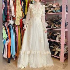 a woman standing in front of a closet full of dresses and shoes on hangers