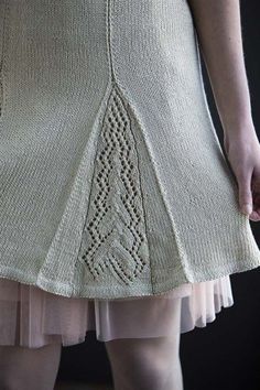 a woman is wearing a skirt made out of knitted material