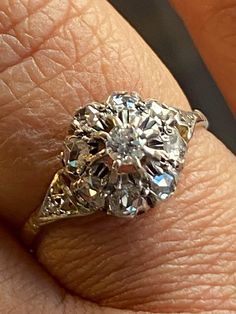 a close up of a person's hand with a diamond ring on their finger