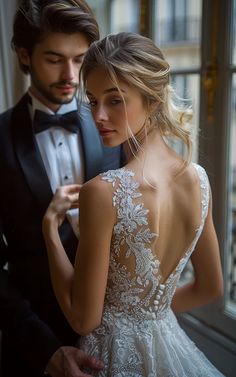 a man in a tuxedo and a woman in a wedding dress standing next to each other