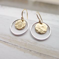 "Hammered 1/3\" gold medallions are encased by sterling silver hoops and dangle from gold filled French hook earwires. Rubber ear clutches included to avoid loss. ~ 1/2\" drop. Lightweight and easy to wear, these dainty earrings also make a great gift. They come in a cute box ready for giving. Dangle Earrings | Mixed Metal Earing | Hammered Gold Coin | Silver Circle Earing | Two Tone Jewelry | Artisan Made | Gift for Women" Hammered Metal Earrings, Everyday Round Brass Jewelry, Everyday Brass Jewelry, Small Hoop Pierced Jewelry As A Gift, Pierced Small Hoop Jewelry As A Gift, Pierced Small Hoop Earrings As A Gift, Small Hoop Earrings Gift, Hammered Sterling Silver Jewelry For Gifts, Hammered Sterling Silver Jewelry Gift