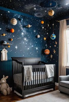 a baby's room with planets and stars painted on the wall, along with a crib